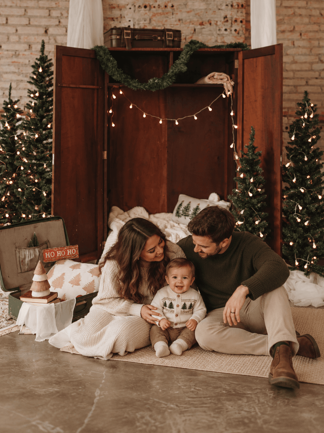 Família sorridente com bebê no cenário de Natal
